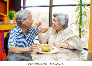 Happy Old Indian  Couple Enjoying Meal Together At Home, Asian Retired Elderly Husband And Wife Eating Noodles, Spend Time. Retirement Life. Love And Care.