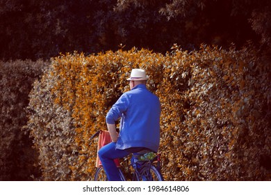 Happy Old Italian Man Riding A Bike In The Countryside. Back View . 