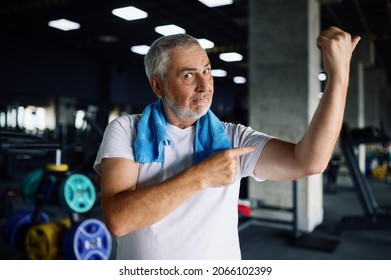 Happy old man shows his muscles in gym - Powered by Shutterstock