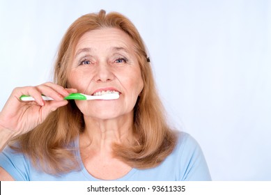 Happy Old Woman Brushing Her Teeth And Smiling