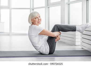 Happy Old Woman Exercising At Gym