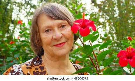 happy old woman nearly red flower