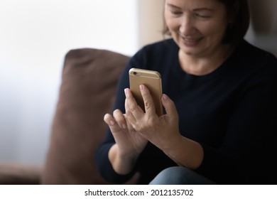 Happy Older 60s Woman Using Telehealth App On Mobile Phone, Making Appointment With Doctor. Mature Lady With Smartphone, Reading Text On Screen, Browsing Internet, Suffering From Addiction. Close Up