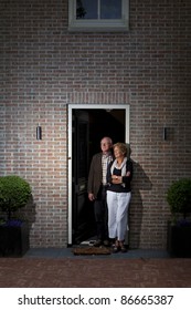 Happy Older Couple In Front Of A House