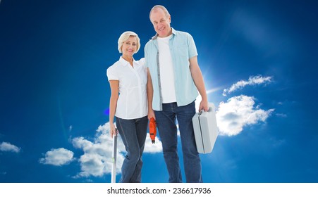 Happy Older Couple Holding Diy Tools Against Cloudy Sky With Sunshine