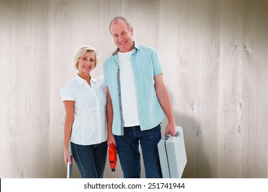 Happy Older Couple Holding Diy Tools Against Wooden Planks