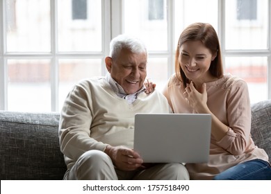 Happy Older Father And Grownup Daughter Looking At Laptop Screen, Having Fun With Computer, Smiling Mature Man And Young Woman Watching Movie, Shopping Online, Sitting On Cozy Couch At Home