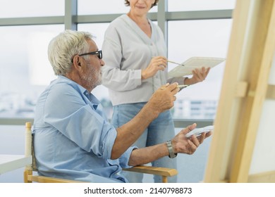 Happy Older Husband, Wife Senior Couple Elderly Family, Caucasian Mature, Adult And Retirement Having Pleasure Together And Painting Picture On Canvas At Home. Freetime, Relaxed Lifestyle Of People.