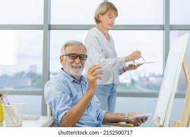 Happy Older Husband, Wife Senior Couple Elderly Family, Caucasian Mature, Adult And Retirement Having Pleasure Together And Painting Picture On Canvas At Home. Freetime, Relaxed Lifestyle Of People.