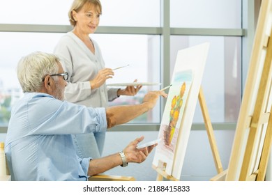 Happy Older Husband, Wife Senior Couple Elderly Family, Caucasian Mature, Adult And Retirement Having Pleasure Together And Painting Picture On Canvas At Home. Freetime, Relaxed Lifestyle Of People.