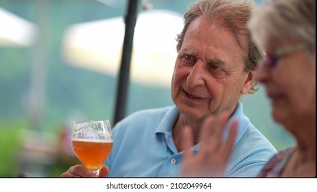 Happy Older Man Drinking Beer With Friends