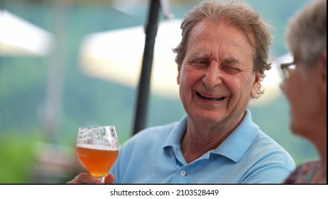 Happy Older Man Drinking Beer With Friends