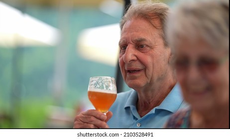 Happy Older Man Drinking Beer With Friends