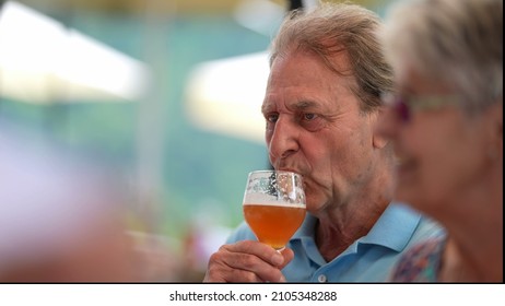 Happy Older Man Drinking Beer With Friends