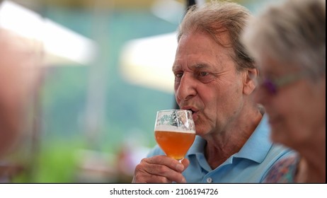 Happy Older Man Drinking Beer With Friends