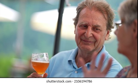 Happy Older Man Drinking Beer With Friends