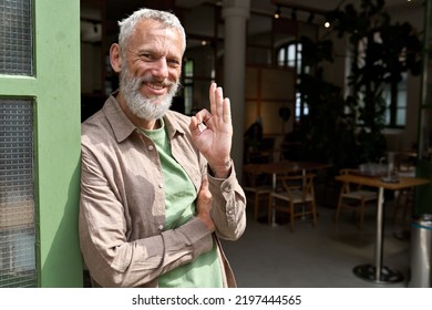 Happy Older Middle Aged Man Small Local Business Owner Showing Ok Hand Sign Standing Outside Cafe Or Bar Giving Recommendation Or Feedback, Suggesting Good Quality Welcoming Clients. Portrait