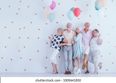 Happy Older People Smiling And Standing With Colorful Balloons At The New Year's Eve Party Photo