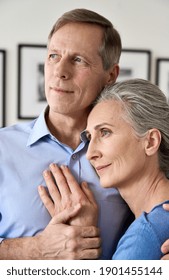 Happy Older Retired Couple Hugging Looking Away, Mature Husband Embracing Smiling Middle Aged Wife, Dreaming Together Of Good Future, Making Plans, Feeling Support, Appreciation And Understanding.