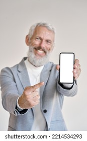 Happy Older Senior Business Man Ceo Wearing Suit Holding Smartphone Pointing At White Mock Up Screen Showing Blank Mobile Display Mockup Template Of Cell Phone For Apps Advertising, Vertical.