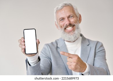 Happy Older Senior Business Man Wearing Suit Holding Smartphone Pointing At White Mock Up Screen Showing Blank Mobile Display Mockup Template Of Cell Phone For Apps Advertising Concept.