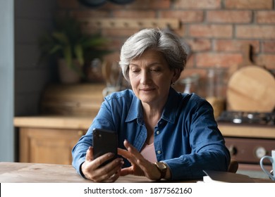 Happy Older Senior Grey-haired Woman Using Smartphone Applications, Enjoying Communicating With Friends In Social Network, Web Surfing Or Shopping Online, Mature People And Modern Tech Concept.