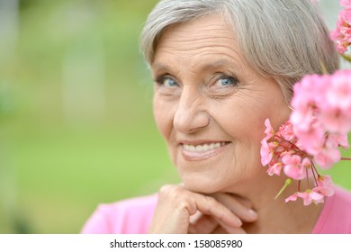 Happy Older Woman With Pink Flower