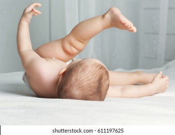 happy one year old baby wearing diapers   in bed at home - Powered by Shutterstock