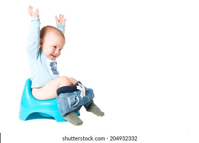 Happy one year old boy having fun on chamber pot, isolated over white background 