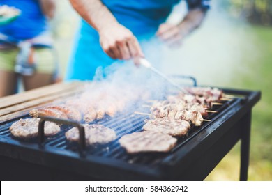 Happy Outgoing People Enjoying Bbq And Grilling Meat