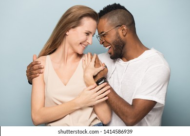 Happy overjoyed young african american man in eyeglasses embracing millennial smiling caucasian woman, touching foreheads, celebrating success, pregnancy notice, special family moments, anniversary. - Powered by Shutterstock