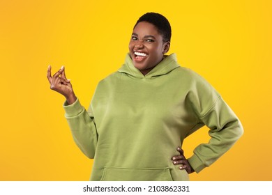 Happy Oversized African American Lady Snapping Fingers Posing Standing Over Yellow Background In Studio, Smiling To Camera. Female Doing Finger Clicking Gesture. It's Easy Concept - Powered by Shutterstock