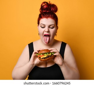 Happy Overweight Fat Woman Happy Hold Burger Cheeseburger Sandwich With Beef In Hand On Yellow Background. Healthy Eating Diet Fast Food Concept