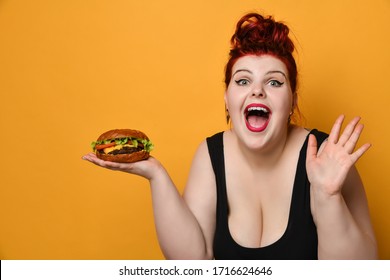 Happy Overweight Fat Woman Happy Hold Big Burger Cheeseburger Sandwich With Beef In Hand Laughing On Yellow Background. Girl On Diet Dieting. Healthy Eating  Fast Food Concept