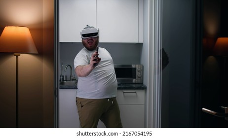 Happy Overweight Man In Augmented Reality Goggles Dance In Kitchen. Fat Guy Have Fun Wearing Vr Headset