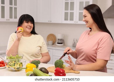 Happy Overweight Women Cooking Together In Kitchen