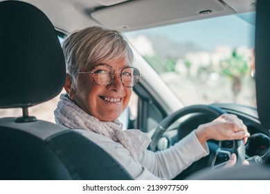 Happy owner. Handsome mature woman sitting relaxed in his newly bought car looking at the camera smiling joyfully. One old senior driving and having fun. - Shutterstock ID 2139977509