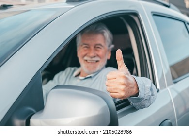 Happy Owner Looking At The Camera With Happy Face And Thumbs Up. Handsome Bearded Mature Man Sitting Relaxed In His Newly Bought Car Looking Out The Window Smiling Joyfully. One Old Senior Driving 