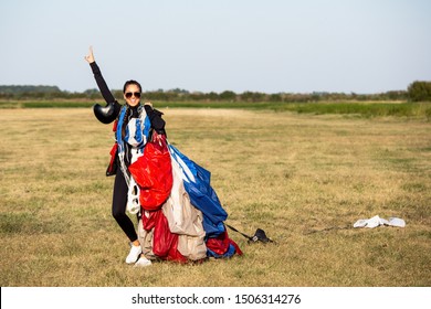 Happy parachute girl jumper after landing.