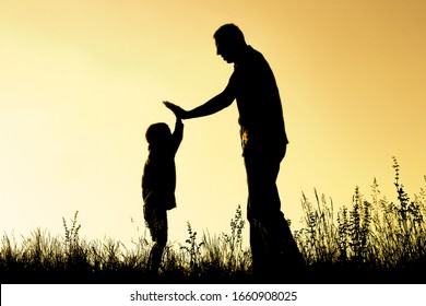 Happy Parent With Child In The Park Outdoors Silhouette