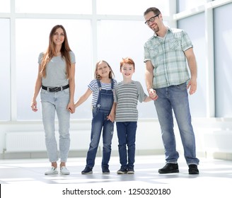 glückliche Eltern mit Kindern, die in einer neuen Wohnung stehen