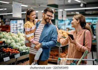 Happy parents with daughter communicating while buying at supermarket.  - Powered by Shutterstock