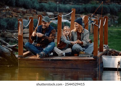 Happy parents with daughter fishing from a pier while enjoying in autumn day by the lake.  - Powered by Shutterstock