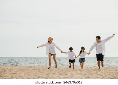 Happy parents hand in hand run and jump with their children on the beach embodying the joy and togetherness of a family vacation by the sea. tourism day concept - Powered by Shutterstock