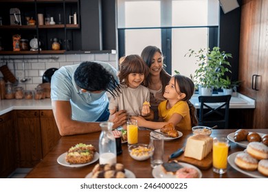 Happy parents having breakfast at kitchen table with children at home, looking at them with love and kindness. Smiling mother and father enjoying their time with kids at breakfast. - Powered by Shutterstock