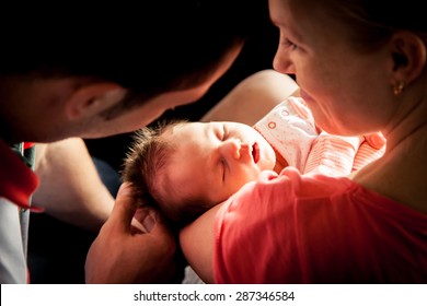 Happy Parents Holding Their Newborn Baby Girl