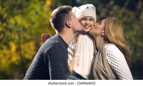 Happy Parents Kiss Cheerful Daughter In Autumn Park, Wealthy Family, Wellbeing