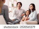 Happy Parents With Little Daughter Sitting Together At Psycholigist