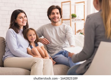 Happy Parents With Little Daughter Sitting Together At Psycholigist's Office After Successful Family Therapy