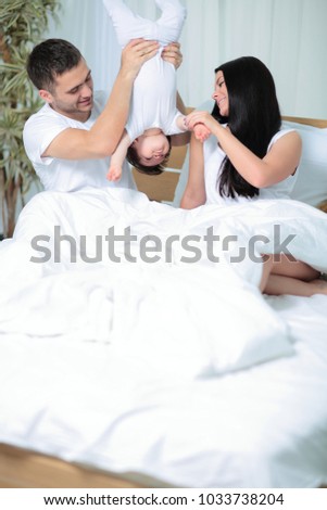 Similar – Mother reading book to her sons in the bed